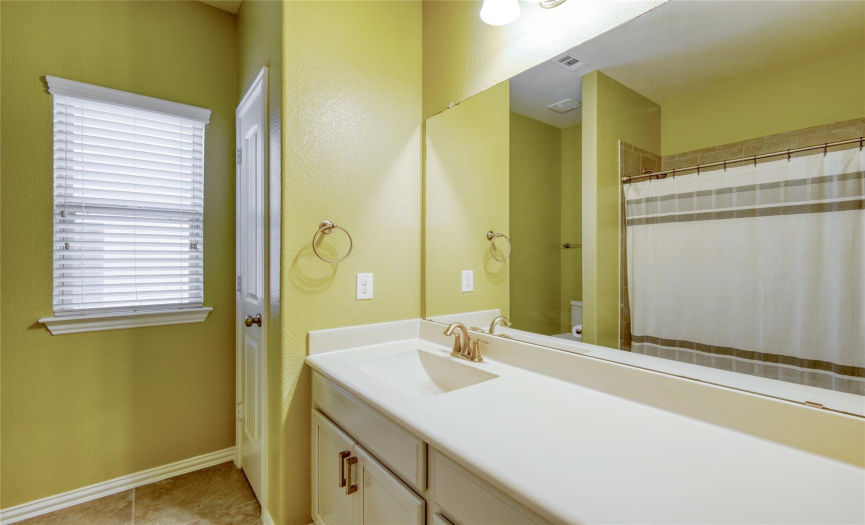 This full bathroom has tile flooring, lots of counter space, and a bathtub/shower combo.