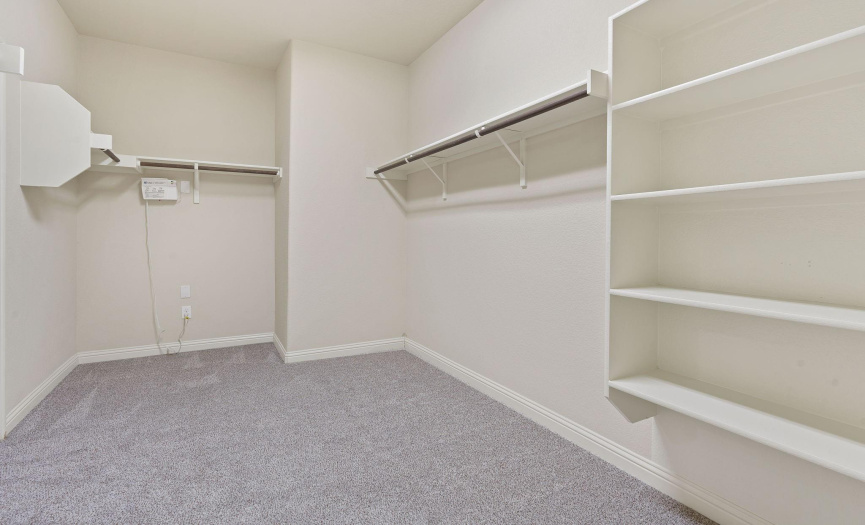 Large walk in closet leads to laundry room