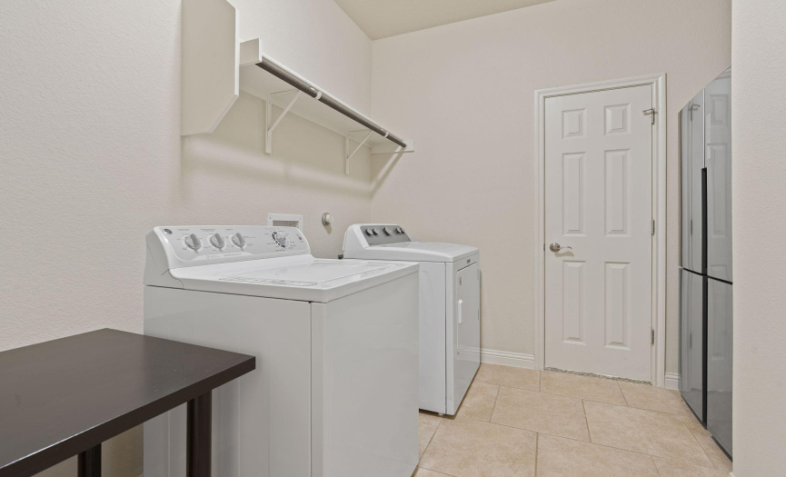 Large laundry room with a refrigerator 