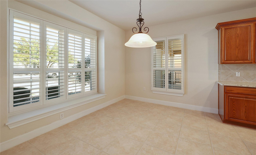 Front yard and front porch views via plantation shutters in your breakfast area.