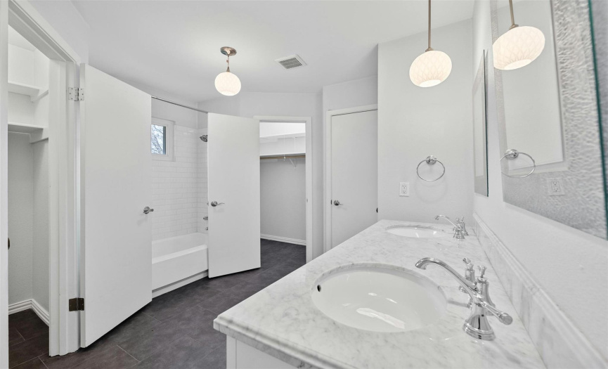 Primary Bathroom - The modern bathroom vanities and lighting fixtures add a touch of luxury. 