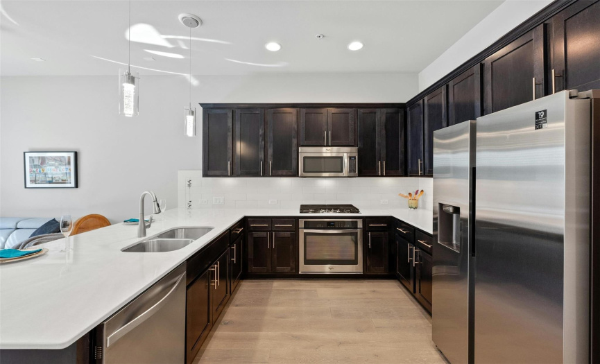 The home chef will love whipping up their favorite culinary delights in this contemporary kitchen with the stainless Whirlpool appliances including a built-in oven, gas cooktop, microwave, and dishwasher.