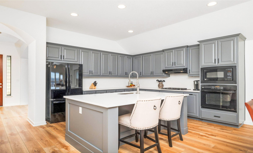 Kitchen has been remodeled with a larger island and beautiful white quartz counter tops.