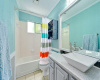 Both bedrooms share a bright bathroom with a vessel sink, stone countertops, and a tub/shower combo.
