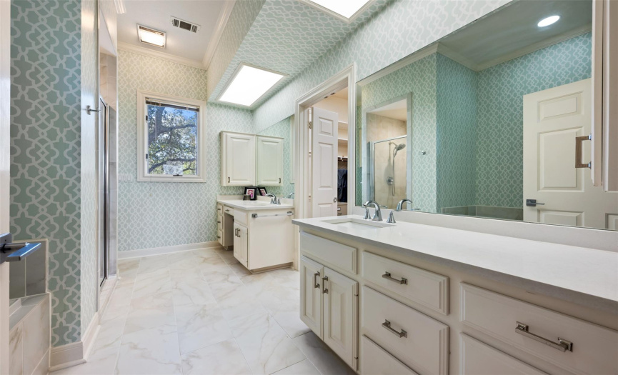 Two large vanities in the primary bathroom, both with excellent storage space. The window overlooks the front of the house. 
