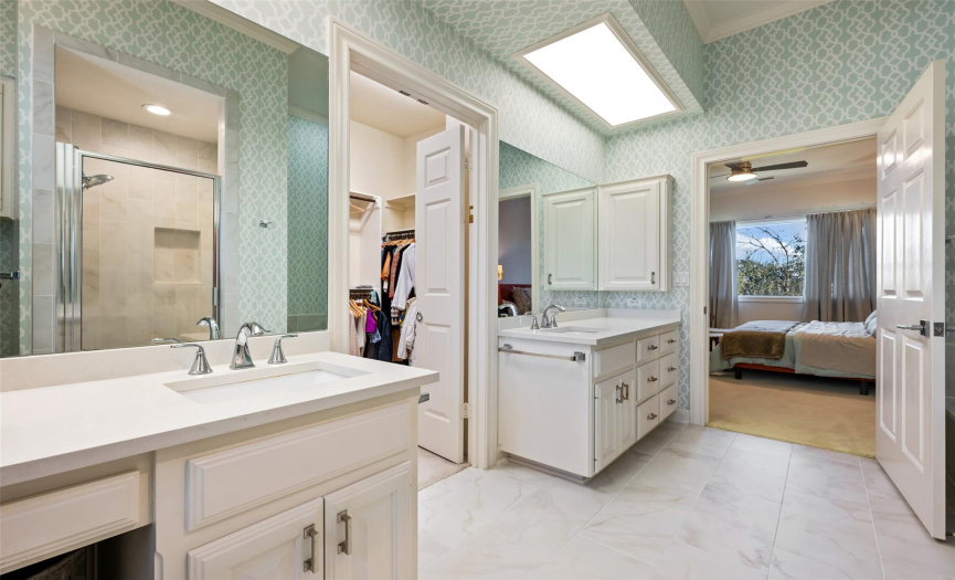 Nice wide tiled floor space in the primary bathroom and thoughtful cabinetry. 