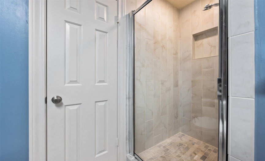 Warm and cozy tiled shower in the lower level shared bathroom. 