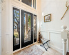 Custom front entry door allows natural light and street views with a covered front porch.