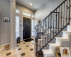 Entryway has an elegant iron staircase leading up to the bedrooms. Carpet updated 2/13/24