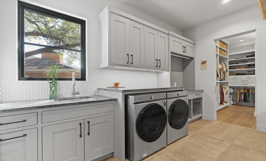 Utility room includes a refrigerator and sink along with plenty of workspace. 