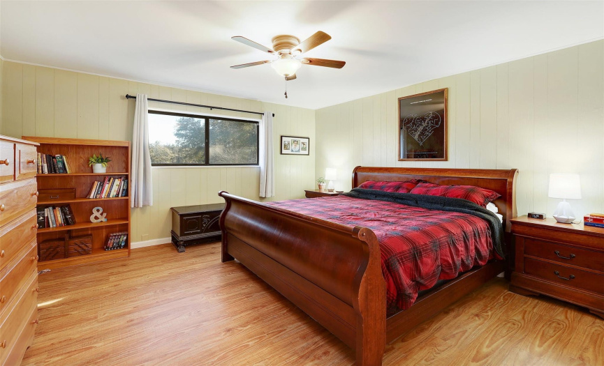 The primary bedroom features vinyl plank flooring and a ceiling fan.
