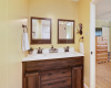 The private bath is well-appointed with a double vanity and two framed mirrors.