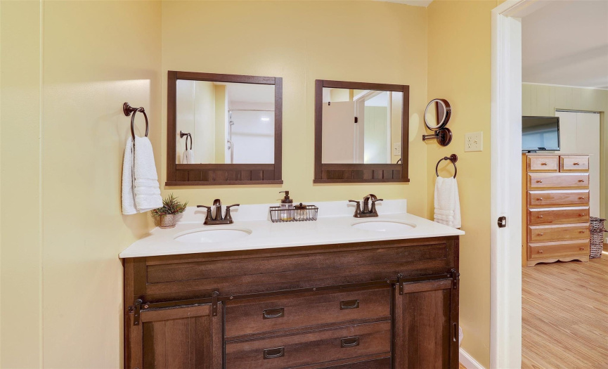 The private bath is well-appointed with a double vanity and two framed mirrors.
