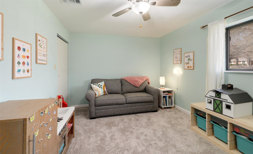 The cozy third bedroom features carpet flooring and a ceiling fan for ultimate comfort and relaxation.