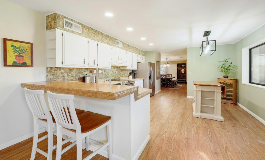 The heart of the home, this kitchen boasts a breakfast bar, ample storage space, and a stainless-steel range.