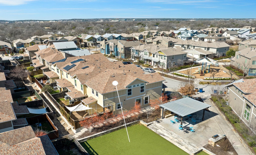 Aerial encompasses the entire home and shows the park divided by a walk way of pavers.