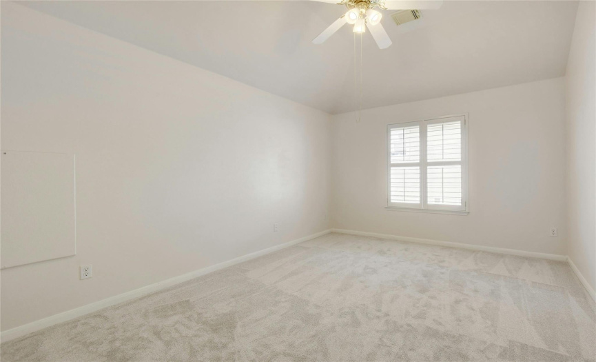New carpet, high ceilings, and a ceiling fan in this bedroom.