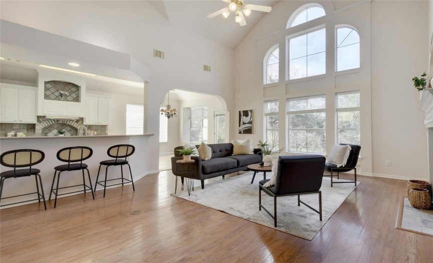 The interior boasts soaring high ceilings, an abundance of natural light, and gorgeous wood flooring throughout.