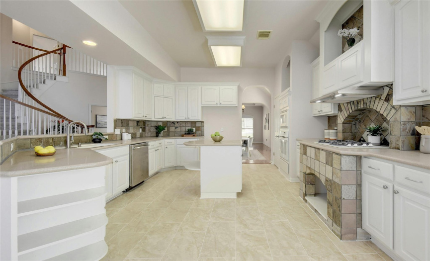 The kitchen features tile flooring, a center island, and plenty of cabinet/countertop space for your kitchen needs.