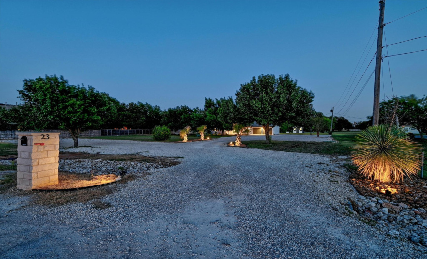 Another view of the landscaped lighting and the long driveway.
