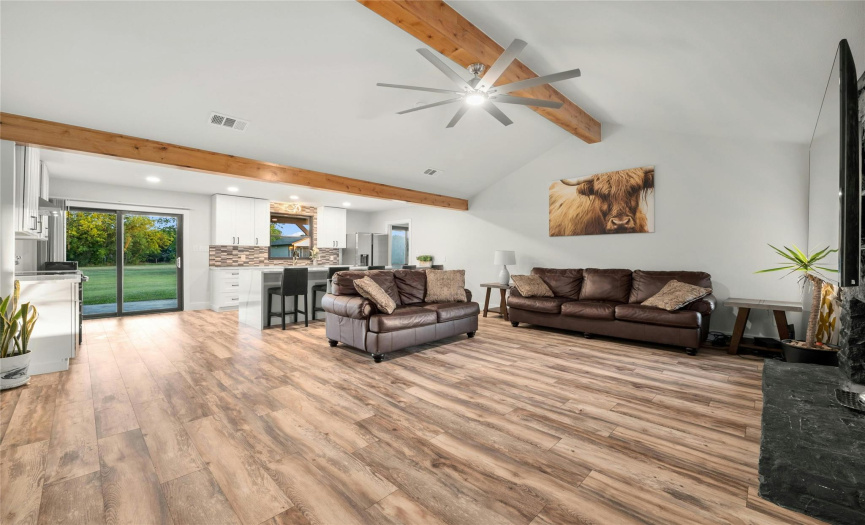 As soon as you enter this completely updated, custom home, you instantly notice all of the luxurious details and touches. The living room has a tall vaulted ceiling, a knotty alder wood beams, gleaming beautiful wood-looking flooring, a large modern ceiling fan and many windows that provide natural lighting.