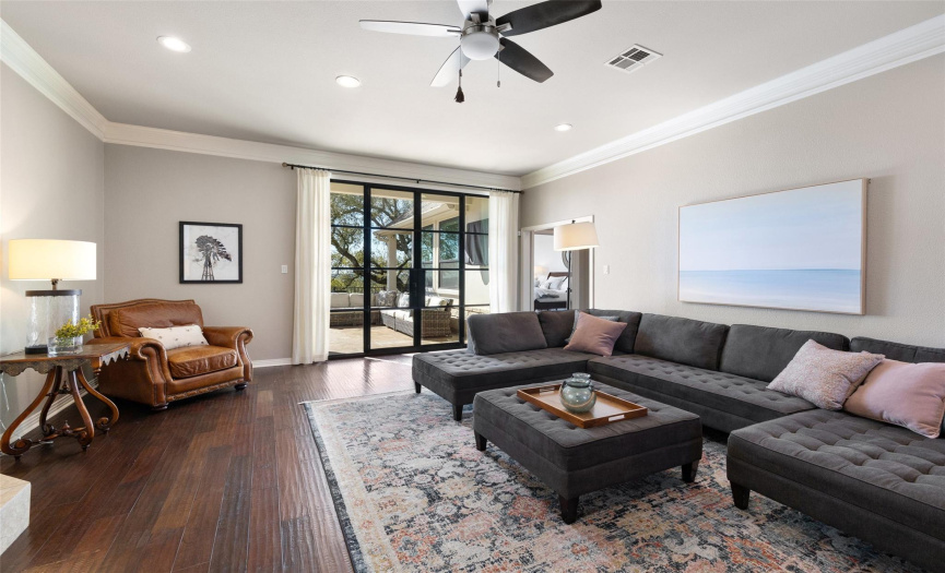 The sunken living room has a gas fire place and views of the hill country beyond the new black metal doors.  