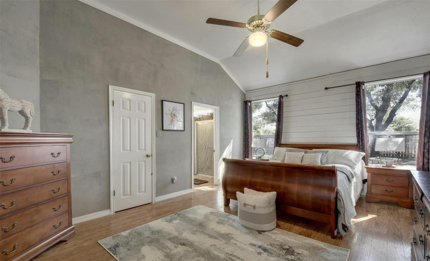 Enter the spacious primary bedroom adorned with crown molding and wood flooring, creating a serene retreat ideal for unwinding after a long day.