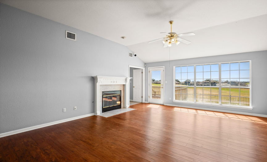 Family room has great views of golf course and offers options for multiple furniture placements with focus on the double sided fireplace