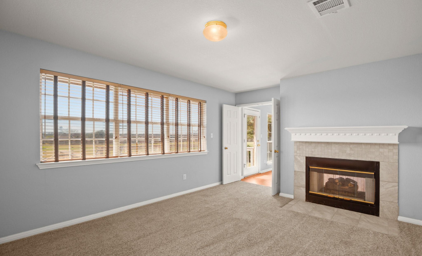 Office/library/den has views of golf course and shares a double sided fireplace with family room