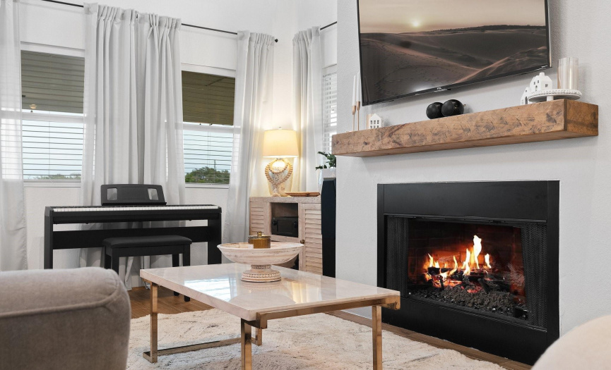 The living room features a comforting fireplace that casts a gentle glow, creating a cozy space to relax and unwind.