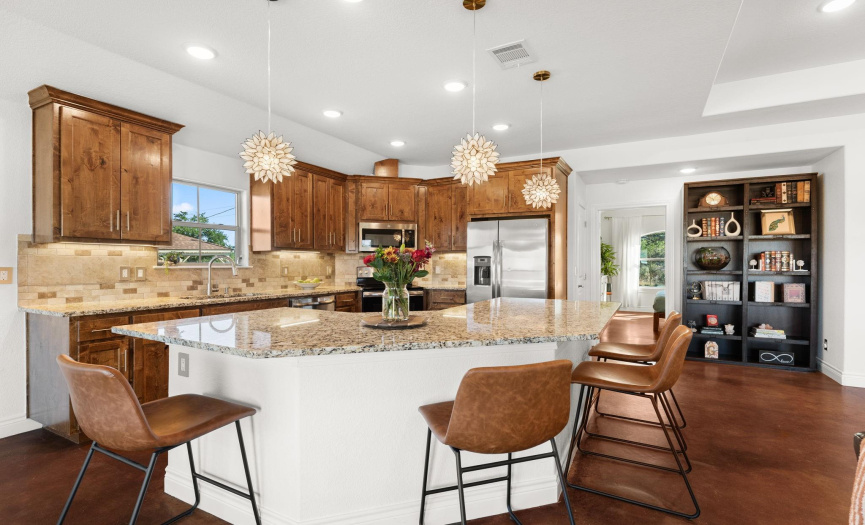 Nice big granite island for entertaining. Lighting is plentiful with a touch of whimsy from the delicate pendant lights