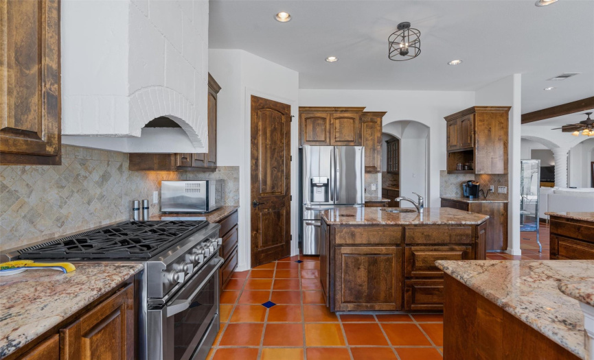 A chef's dream, the kitchen is equipped with top-of-the-line stainless steel appliances, including a professional-grade range, oven and range hood.