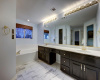 Primary bathroom with dual vanities and exceptional soaking tub.