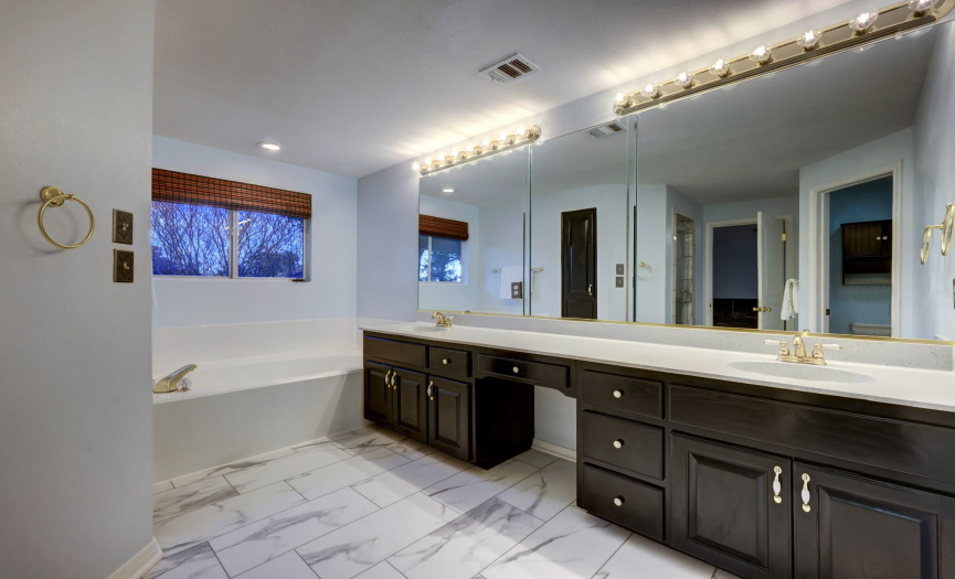 Primary bathroom with dual vanities and exceptional soaking tub.