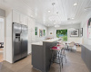 Kitchen equipped with an eat-at bar, cozy dining nook, and modern stainless steel appliances