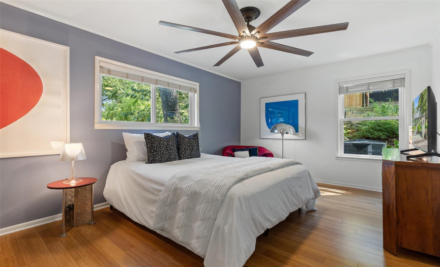 Generously sized bedroom flooded with abundant natural light and equipped with a ceiling fan