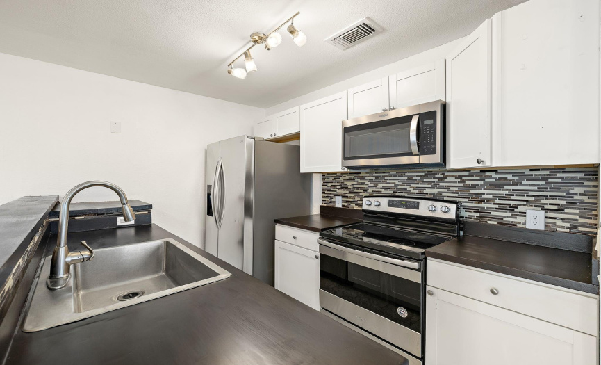 This updated kitchen includes updated tile and stainless steel appliances.