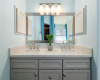 The primary bathroom features dual sinks in an on-trend grey vanity topped with engineered quartz counters.  