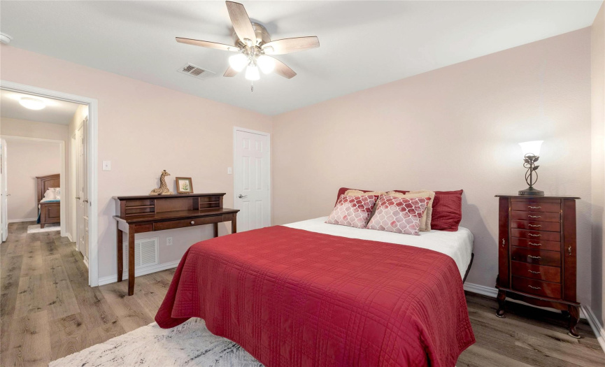On the opposite side of the home you’ll find two secondary bedrooms, both with ceiling fans and walk-in closets.  This is the back bedroom.