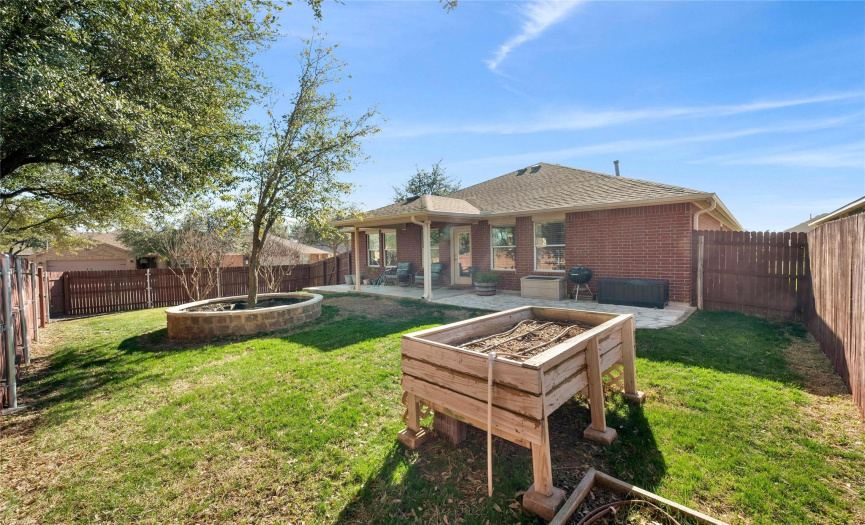 The enclosed backyard features a mature oak tree in a retaining bed with irrigation, and an irrigated raised garden bed awaits your green thumb.  