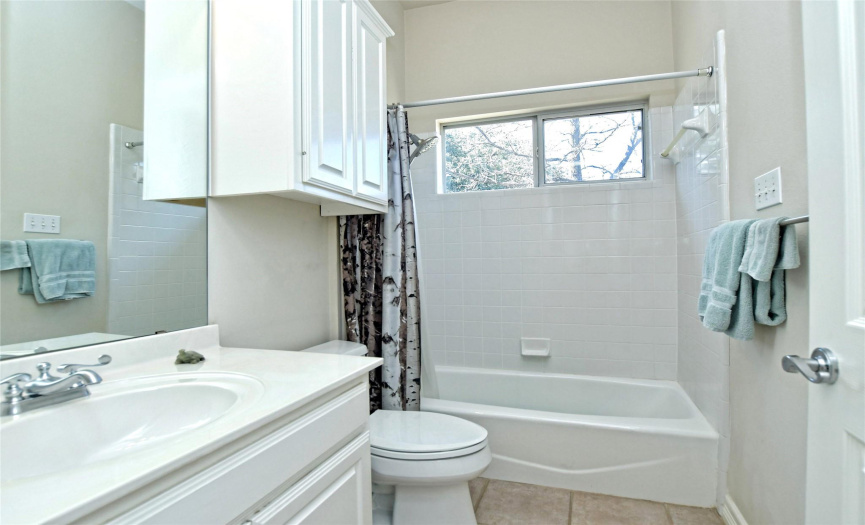 The full secondary bath provides a single vanity and a shower/tub combo with tile backsplash. 