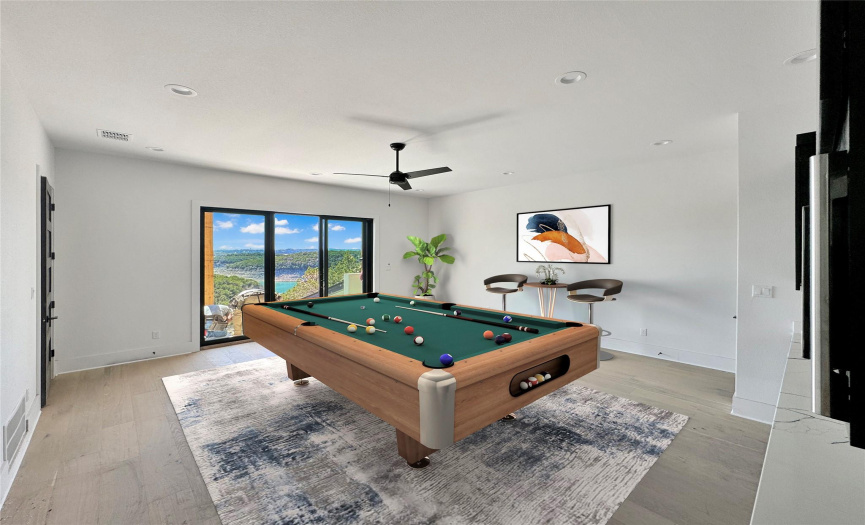 Indulge in unrivaled views from the second-floor game room, where panoramic scenes steal the spotlight. Although not captured in this image due to the angle, a generously appointed wet bar awaits, complete with a built-in microwave and a designated space for an integrated beverage cooler. Virtually staged.