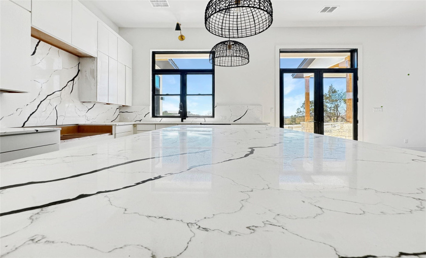 Explore luxury in progress with quartz countertops adorning a sizable kitchen island in this home, currently undergoing construction. Numerous gorgeous cabinets promise abundant storage, marrying style with practicality.