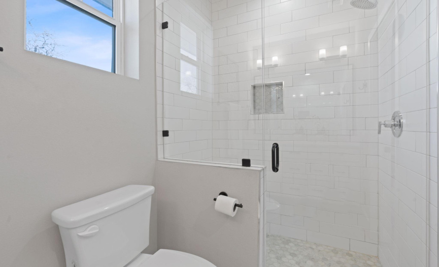 Gorgeous frameless glass enclosed walk-in shower with subway tile surround. 