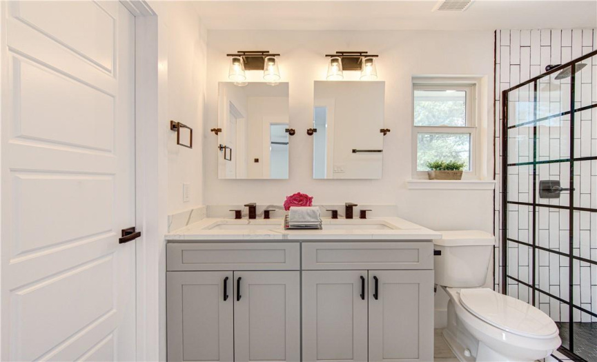 The modern and completely redone spa-inspired master bathroom includes double sinks and a standalone shower.