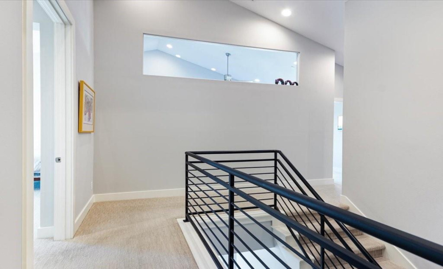 The staircase with open railing leads to the 2nd floor 3 bedrooms, 3 full baths and 2nd living area