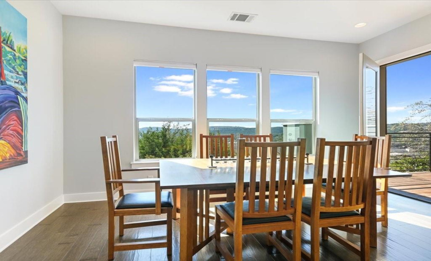 The dining area accommodates a large table and chairs and the atrium door leads to the deck