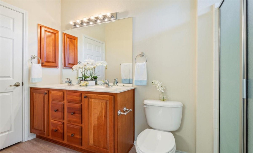 Primary bathroom with dual sinks and cherry cabinets