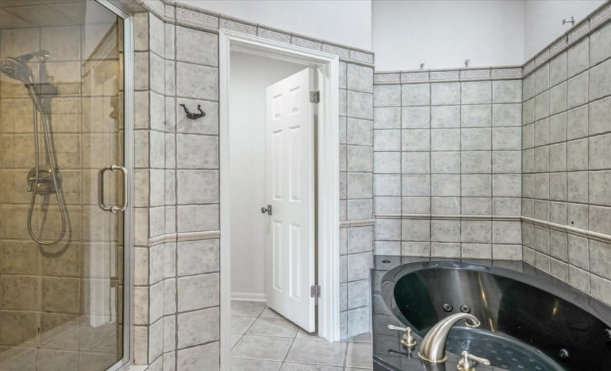 Enjoy modern convenience in the primary bathroom, boasting a separate walk-in shower and a huge jetted tub, providing both functionality and indulgence for everyday comfort.