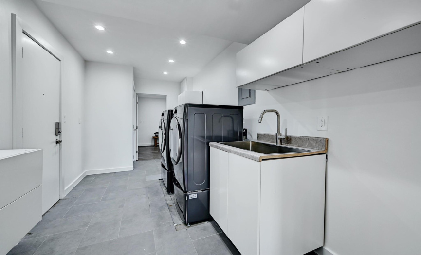 A huge laundry room is located off the family room with lots of built-in storage, a sink, and plenty of room for a second refrigerator or deep freezer.